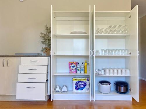 a white pantry with white doors and shelves at Kingsland Big Family Comfort House in Auckland