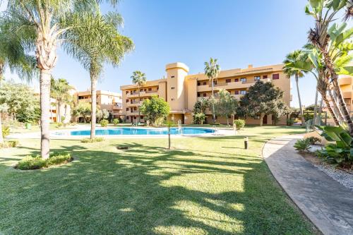 a resort with a swimming pool and palm trees at Azul Cala Mijas Apartment in La Cala de Mijas