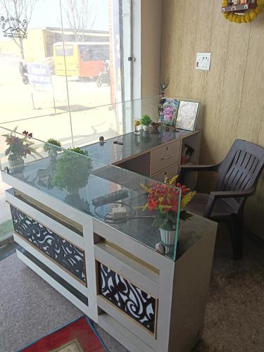 Un escritorio con una tapa de cristal con plantas en macetas encima. en Govardhan Seva Sadan govardhan, en Govardhan
