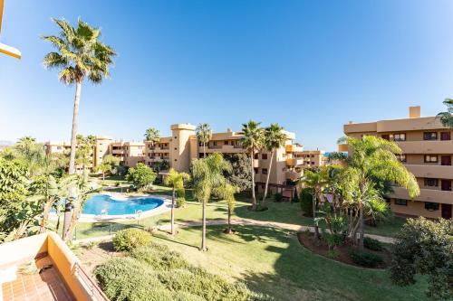 an aerial view of a resort with a swimming pool and palm trees at Azul Cala Mijas Apartment in La Cala de Mijas