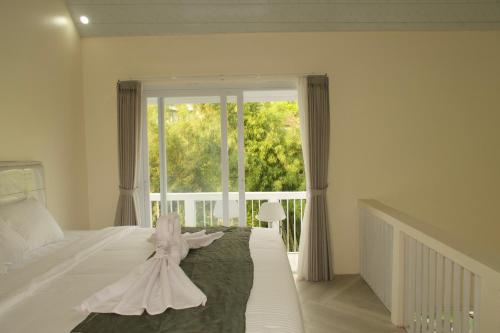 Un dormitorio con una cama blanca con un vestido. en Villa Pangkung, en Uluwatu