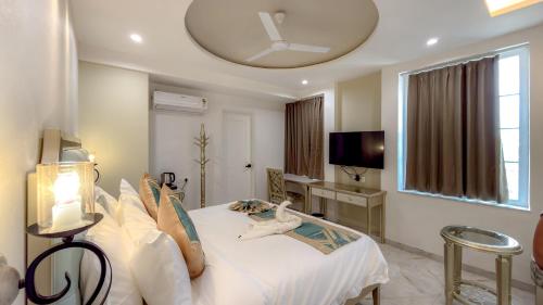 a bedroom with a white bed and a large window at Studio by Jardin in Indore