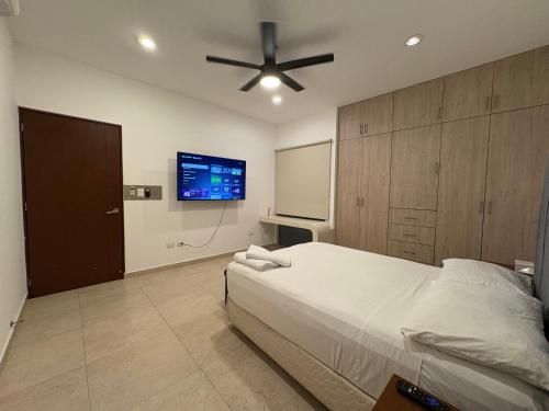 a bedroom with a bed and a flat screen tv at Hotel Suites Reyvaj in Mérida
