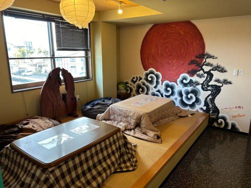a room with a table and a painting on the wall at Guest House Matsu in Osaka