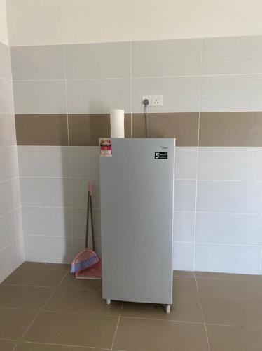 a small white refrigerator in a corner of a room at Banglo Jasin Perdana in Bemban