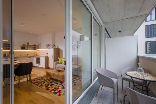 Zimmer mit Glaswänden und einem Esszimmer mit Tisch und Stühlen in der Unterkunft Private Living Apartments in Kufstein