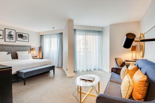 a hotel room with a bed and a couch at Columbus Hotel Monte-Carlo, Curio Collection by Hilton in Monte Carlo