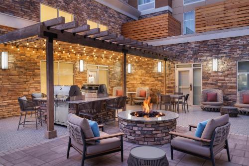 a patio with a fire pit with chairs and tables at Homewood Suites By Hilton Thornton Denver in Thornton