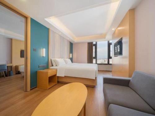 ein Hotelzimmer mit einem Bett und einer Couch in der Unterkunft Lavande Hotel·Dongxing Port in Dongxing