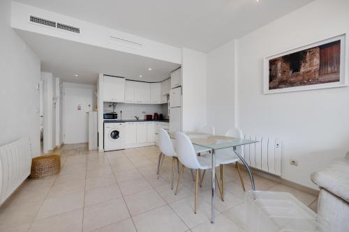 a white kitchen with a table and white chairs at CB Living - Apartment with roof terrace Aguamarina in Orihuela Costa