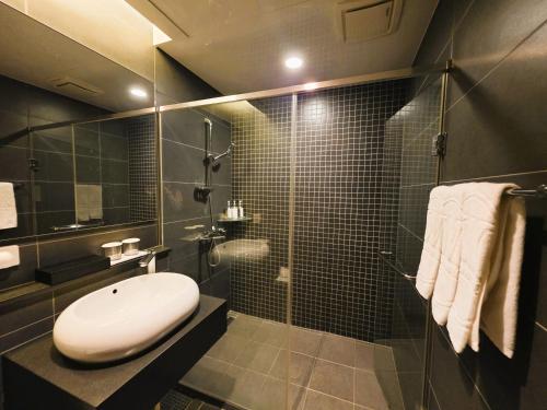 a bathroom with a shower with a sink and a toilet at W Residence Hotel in Busan