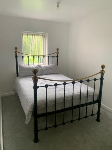 3 Bedroom Contractor house Glebe في ريتفورد: غرفة نوم بسرير أسود مع ملاءات بيضاء ونافذة