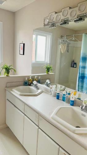 a bathroom with two sinks and a large mirror at warm house2 in Coquitlam