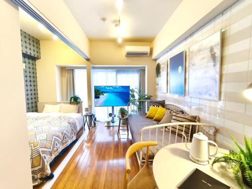 a bedroom with a bed and a living room with a table at Nishiki Stay Takamatsu101 in Takamatsu