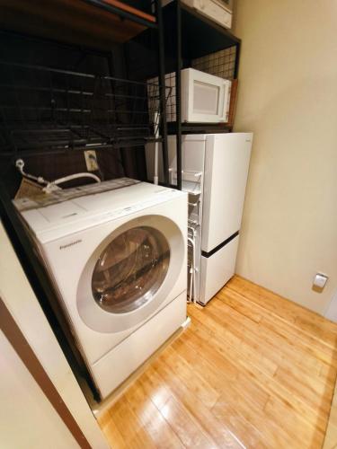 a washing machine in a kitchen with a microwave at Nishiki Stay Takamatsu101 in Takamatsu