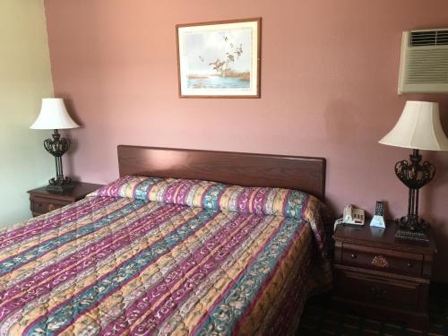 a bedroom with a bed and two night stands with lamps at Best Value Inn Motel Sandusky in Marianna