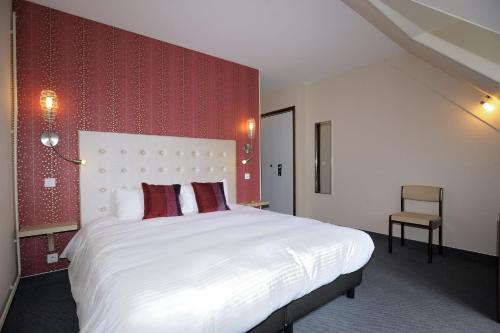 a bedroom with a large white bed with red walls at Le Relais De La Poste in Neuvéglise