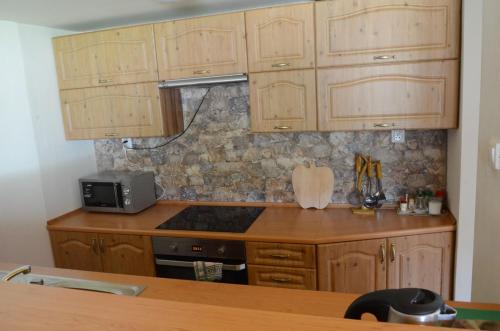 cocina con armarios de madera y fogones en Dolinka Holiday Home, en Levoča