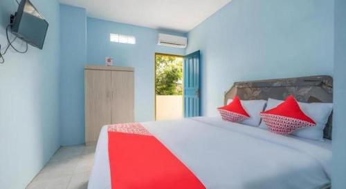 a bedroom with a large bed with red and white pillows at Hotel O RF Homestay in Pamanjengang