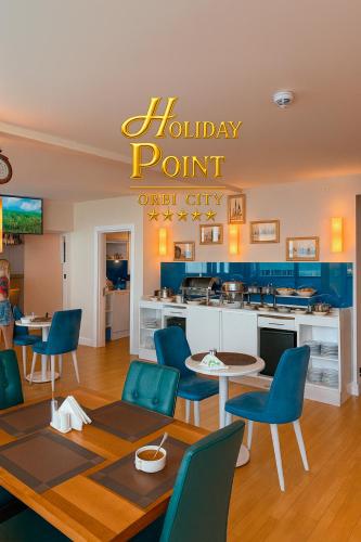 a dining room with a happy point chili city sign at Holiday Point Orbi City in Batumi