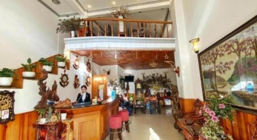 Ein Mann, der an einer Theke in einem Zimmer sitzt. in der Unterkunft Gold Night Hotel in Da Lat