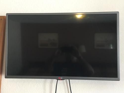 a flat screen tv sitting on a wall at Best Value Inn Motel Sandusky in Marianna