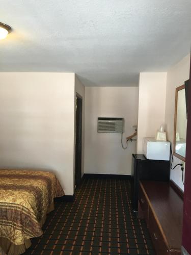 a hotel room with a bed and a mirror at Best Value Inn Motel Sandusky in Marianna