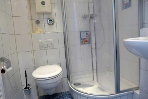 a bathroom with a shower and a toilet and a sink at Tief 10 Austernfischer 708 in Wangerland