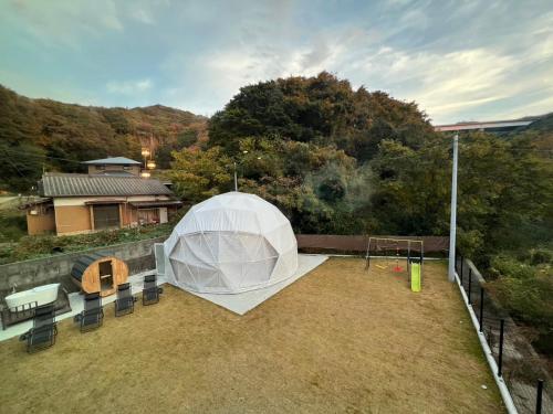 una tenda bianca con un parco giochi in un cortile di Awaji Play Resort a Minamiawaji