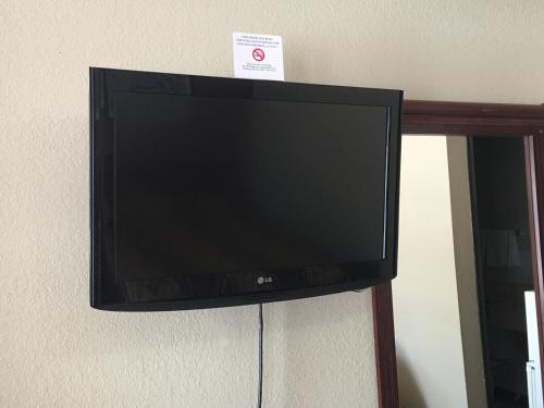 a flat screen tv hanging on a wall at Best Value Inn Motel Sandusky in Marianna