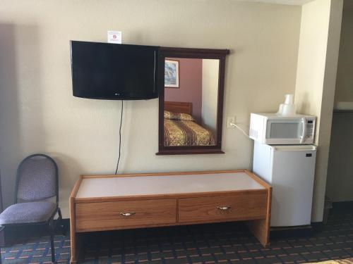 a room with a tv and a dresser with a microwave at Best Value Inn Motel Sandusky in Marianna