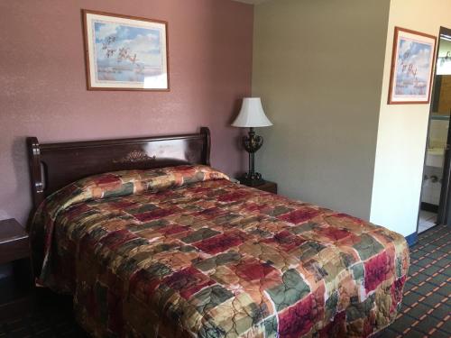 a bedroom with a bed with a quilt on it at Best Value Inn Motel Sandusky in Marianna
