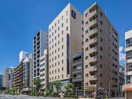 um prédio alto e branco em uma rua da cidade em Comfort Hotel Tokyo Higashi Nihombashi em Tóquio