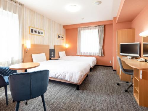 a hotel room with a large bed and a desk at Comfort Hotel Maebashi in Maebashi