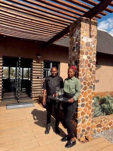 a man and a woman holding a tray of wine glasses at Gweda Lodge in Ouklip