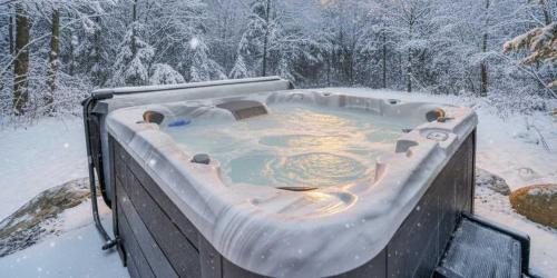 een hot tub bedekt met sneeuw in een tuin bij Spa & Pool table - Ivy Cottage in Scott