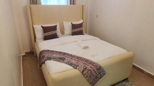 a small bedroom with a bed with a headboard at Naivasha Naivegas C5 Staycation by Charlie izzy in Munyu