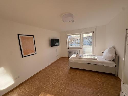 Altstadtperle Ettlingen mit Smart TV und WLAN في إيتلينغن: غرفة نوم صغيرة بها سرير ونافذة