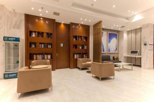 a lobby with chairs and bookshelves in a building at City Comfort Inn Wuhan Rui'an Street Metro Station in Wuhan