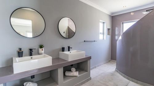 a bathroom with two sinks and a mirror at Skobbejak in Paternoster
