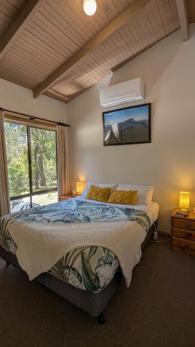 a bedroom with a large bed and a window at Wonderland Cottages in Halls Gap
