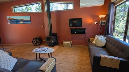 a living room with a couch and a wood stove at Wonderland Cottages in Halls Gap