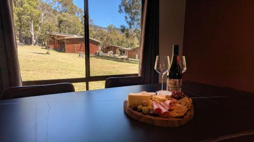 a plate of food on a table with a bottle of wine at Wonderland Cottages in Halls Gap