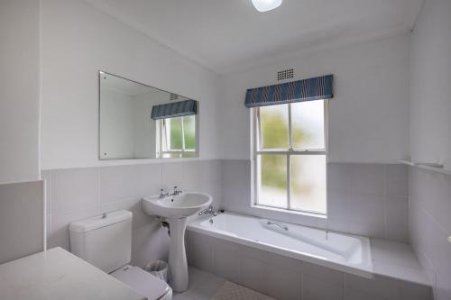a bathroom with a sink and a toilet and a bath tub at 1 Mustique River Club in Plettenberg Bay