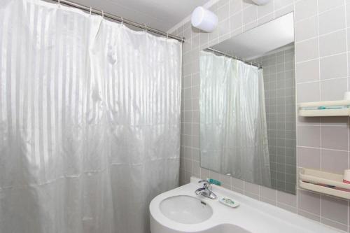 ein Badezimmer mit einem weißen Duschvorhang und einem Waschbecken in der Unterkunft Jinjiang Inn Zhenjiang Jiangsu University Suning Plaza in Zhenjiang