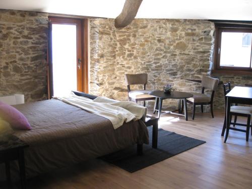 a bedroom with a bed and a table and chairs at Candeias do Souto in Bragança