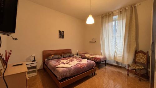 Appartamento Camere Vacanze Debora في بوريتا تيرمي: غرفة نوم بسريرين ومكتب ونافذة