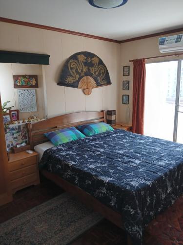 a bedroom with a bed with a blue comforter at Great Value Residence in Bangna