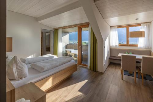 Un dormitorio con una cama y una mesa y sillas. en Residence Egger, en Terlano