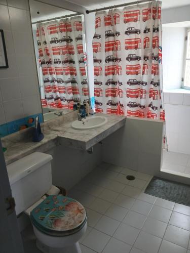 a bathroom with a toilet and a sink and a shower curtain at Great Value Residence in Bangna